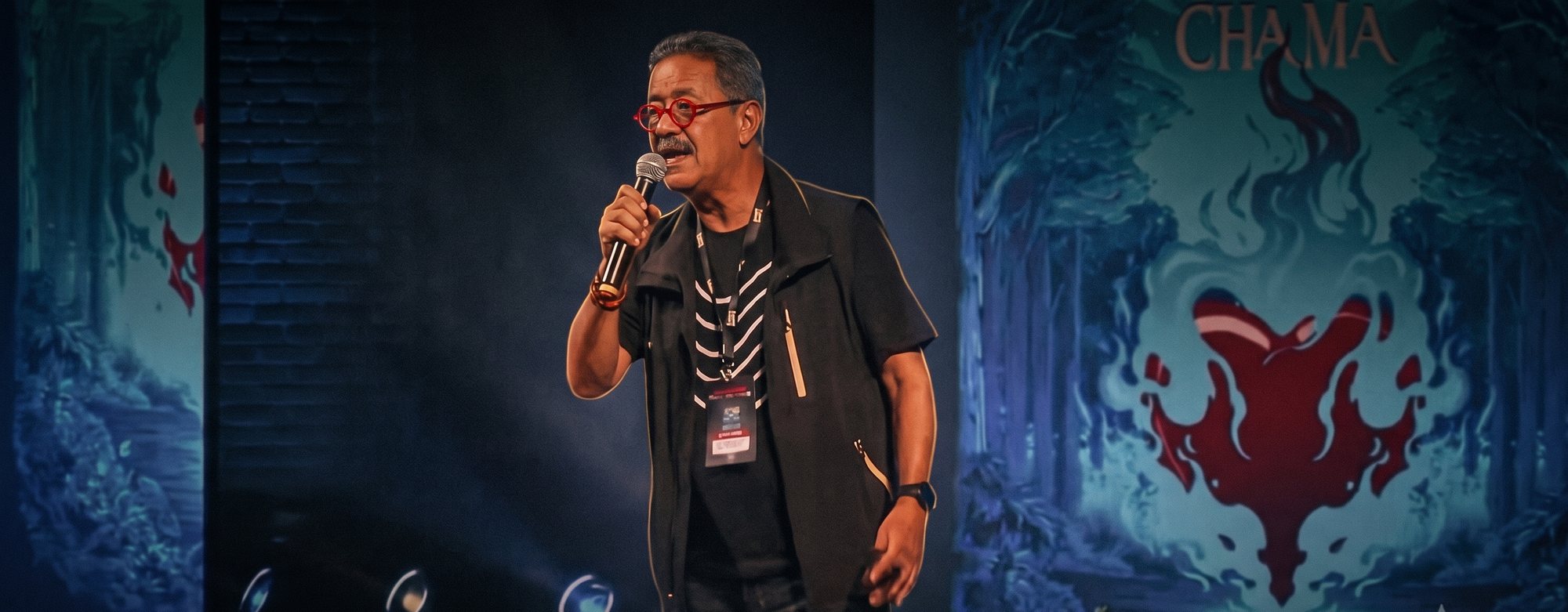 Toninho da Galeria do Rock durante uma palestra, ao microfone no palco